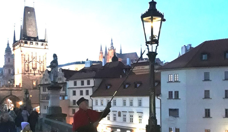 Lampář na Karlově mostě opět rozsvěcuje plynové lampy