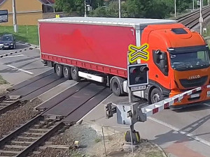 VIDEO: Řidič kamionu ignoroval červenou na přejezdu, kvůli vlaku pak prorazil závory