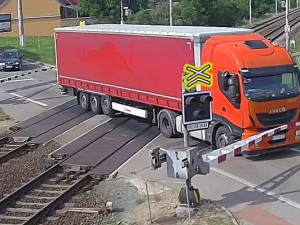 VIDEO: Řidič kamionu ignoroval červenou na přejezdu, kvůli vlaku pak prorazil závory