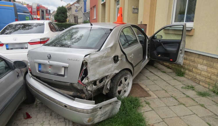 FOTO: Řidič jel příliš rychle. Po smyku narazil do dvou domů a auta