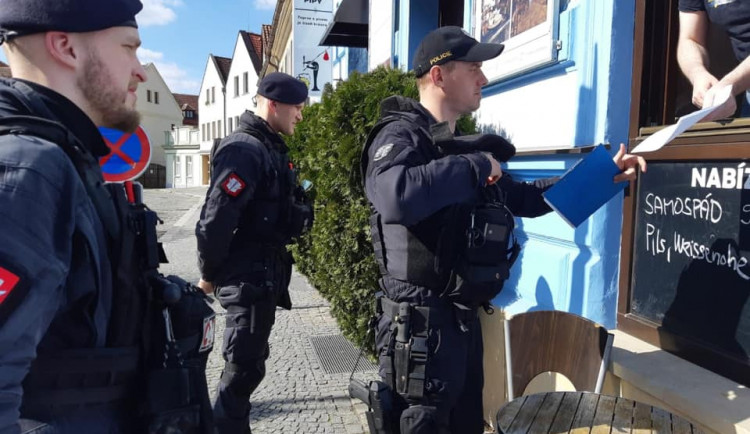 Policie při kontrole uzavřeného obchodu.