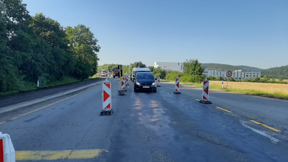 Dělníci opravují křižovatku u Kuřimi. Na tahu na Svitavy stojí řidiči z obou směrů v kilometrových kolonách