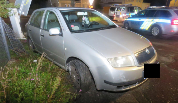 Řidič v opilosti nabral dopravní značku a skončil v plotě domu