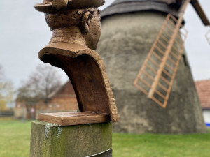 Na větrný mlýn dohlíží busta lidového vypravěče Václava Mlýnka z Kuželova
