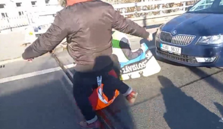 VIDEO: Aktivisté v Praze opět zablokovali dopravu. Jeden z řidičů kopal do aktivisty na zemi