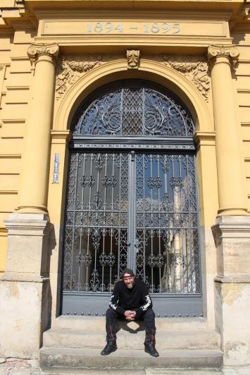 Umělecký kovář Pavel Vágner před restaurovanou mříží na budově gymnázia ve Dvoře Králové nad Labem