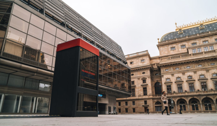 U Národního divadla stojí telefonní budka. Vypráví příběhy lidí v nouzi.