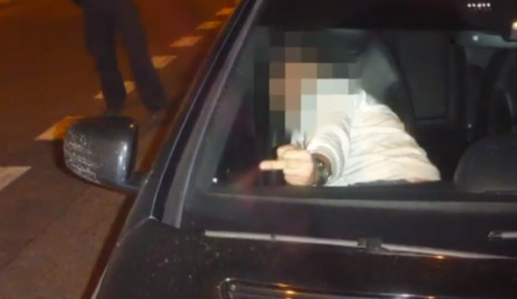 VIDEO: Řidič se pokoušel usnout na zemi vedle auta. Nakonec se vyspal na záchytce