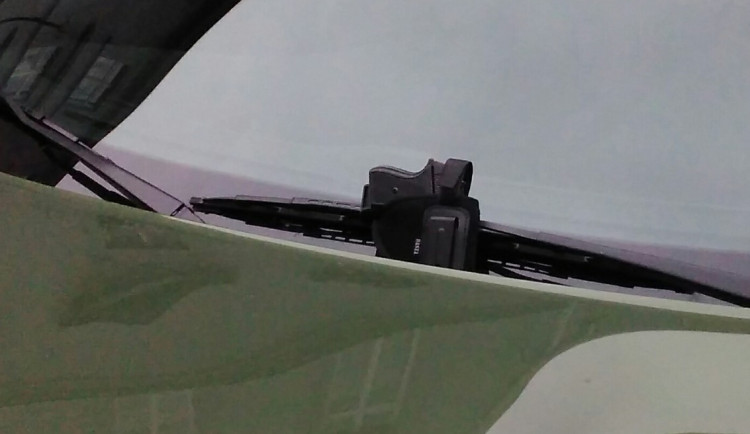 Muž zaparkoval a telefonoval. Mezitím mu někdo beze slov dal zbraň za stěrač a odešel