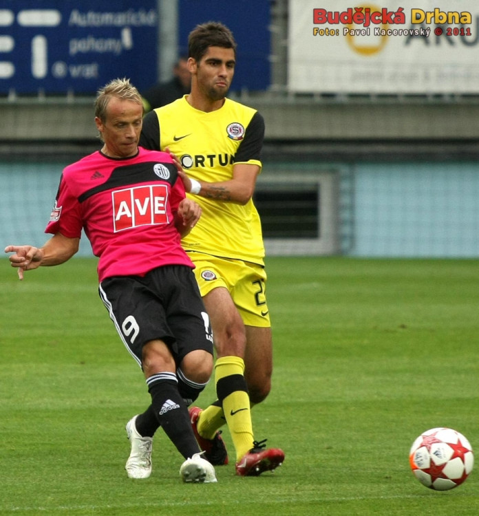 Otepka odehrává míč před Lubošem Huškem