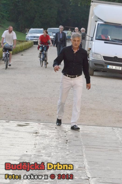 Přichází. Tvář ustaranou, unavený krok