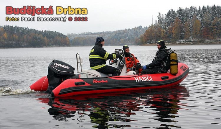 Jiří Urban (uprostřed) odjíždí na člunu označit místo, odkud bude druhý potápěč zachraňován