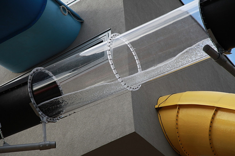 Průhledný díl tobogánu vedeného venkem budovy