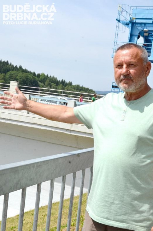 Daniel Barcal ukazuje na korunu hráze, přes kterou vede most do Přední Výtoně