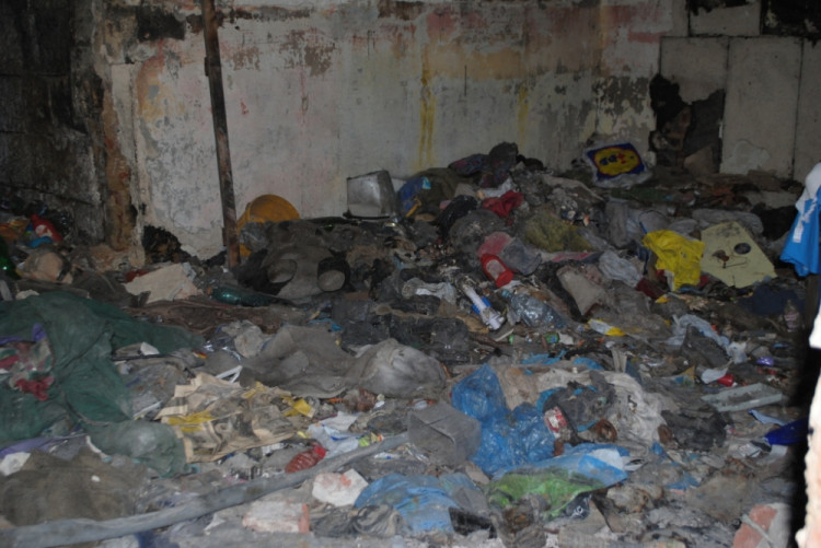 Větší místnost je zaplavená odpadky