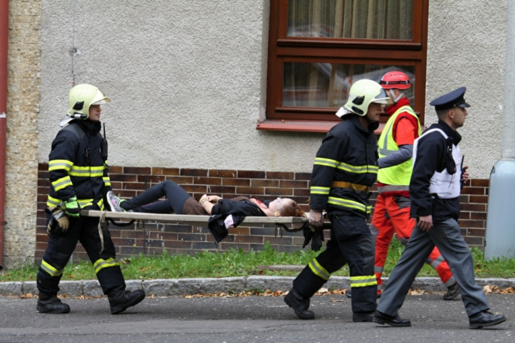 Hasiči odnášejí zraněného