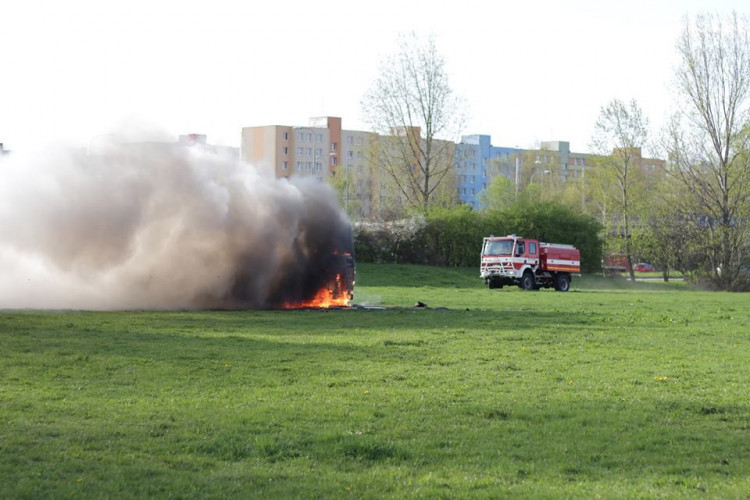 Požár vraku autobusu na louce u Vltavy v Českých Budějovicích
