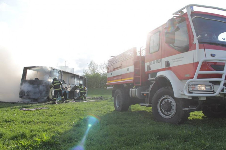 Požár vraku autobusu na louce u Vltavy v Českých Budějovicích