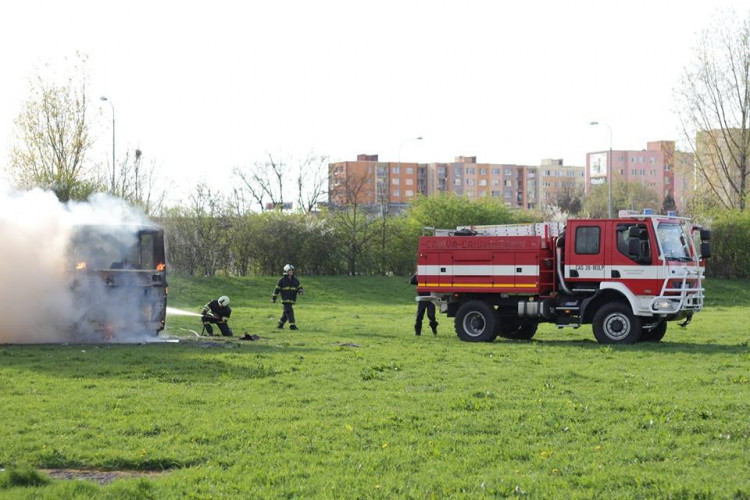 Požár vraku autobusu na louce u Vltavy v Českých Budějovicích