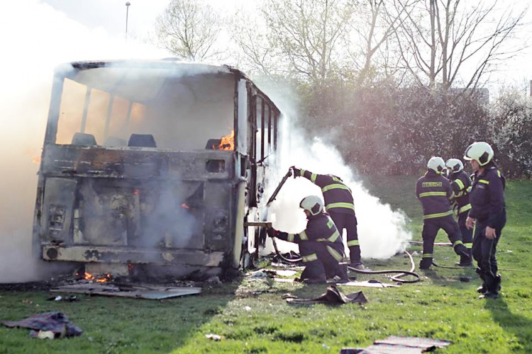 Požár vraku autobusu na louce u Vltavy v Českých Budějovicích