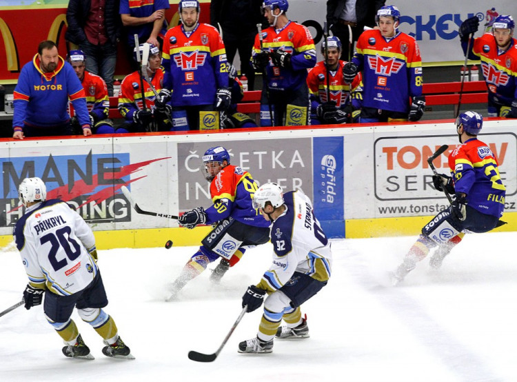 Mladý útočník Motoru Matěj Toman prohazuje puk mezi Přikrylem a Strnadem