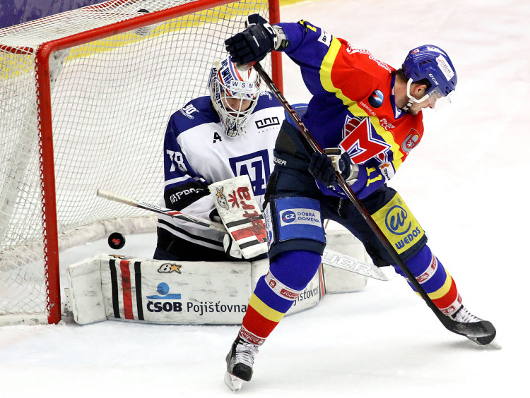 Miloslav Čermák se snaží na vrcholku brankoviště tečovat kotouč za záda Růžičky