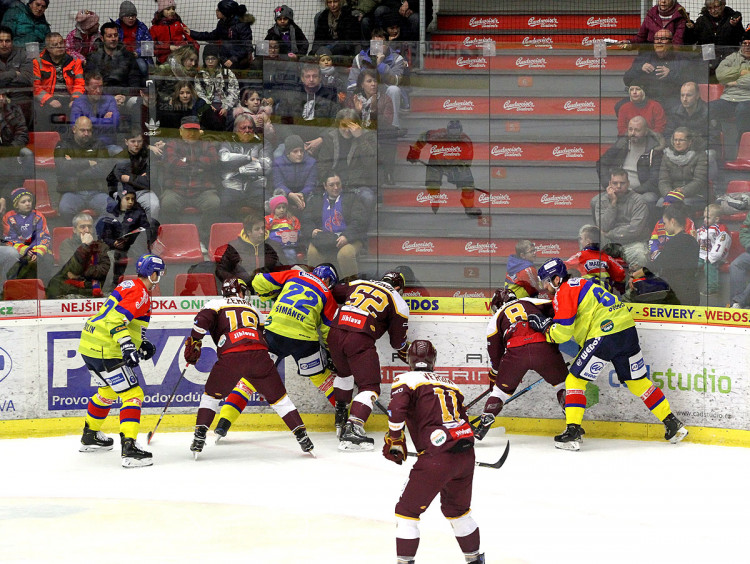 Jeden z mnoha soubojů o puk u mantinelu