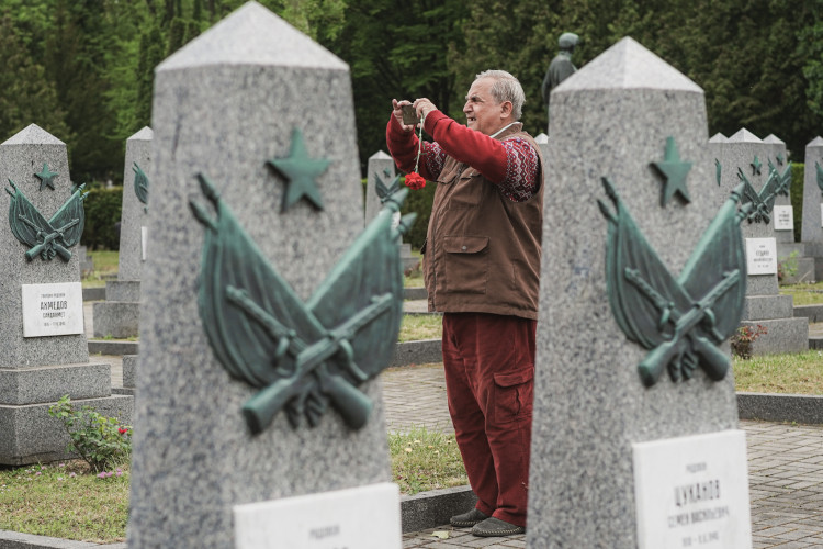 FOTOGALERIE: Vztyčené prostředníčky, karafiáty a ruské vlajky. Podívejte se, jak vypada návštěva Nočních vlků na Olšanských hřbitovech