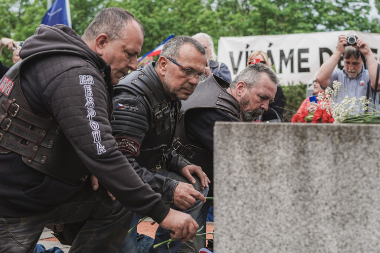 FOTOGALERIE: Vztyčené prostředníčky, karafiáty a ruské vlajky. Podívejte se, jak vypada návštěva Nočních vlků na Olšanských hřbitovech