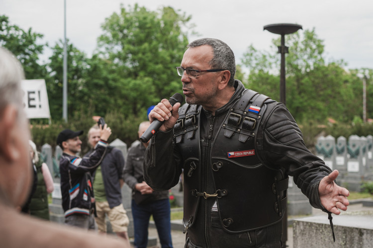 FOTOGALERIE: Vztyčené prostředníčky, karafiáty a ruské vlajky. Podívejte se, jak vypada návštěva Nočních vlků na Olšanských hřbitovech