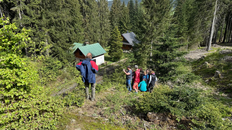 Lidé sledují místo, kudy vjíždí vlak do tunelu ze strany od Brčálníku