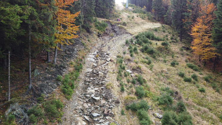 Několik set metrů dlouhá erozní rýha pod lanovkou na Velký Klínovec s menším sesuvem na Milionové cestě