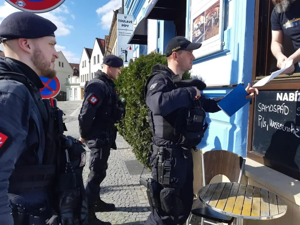 Policie při kontrole uzavřeného obchodu.
