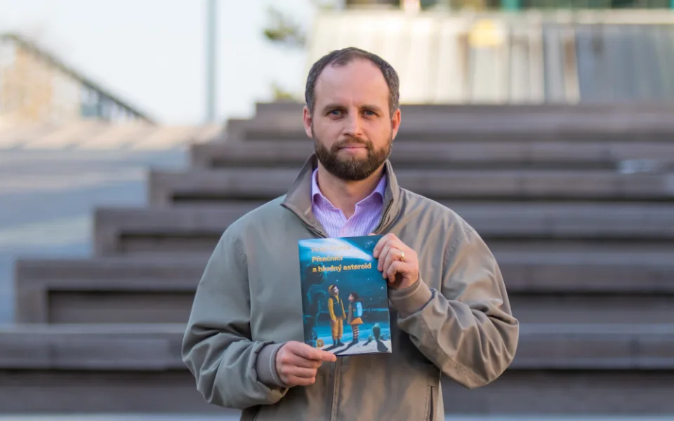 Akademik Václav Dvořák se svou knihou Písečníci a bludný asteroid.