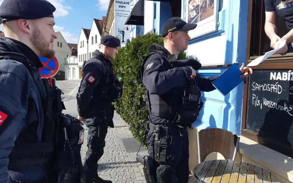 Policie při kontrole uzavřeného obchodu.